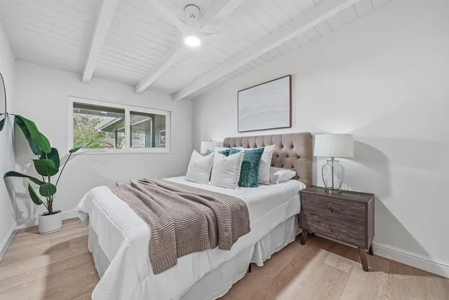a bedroom with bed and wooden floor
