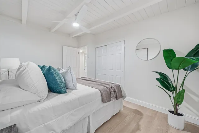 a bedroom with a bed and potted plant