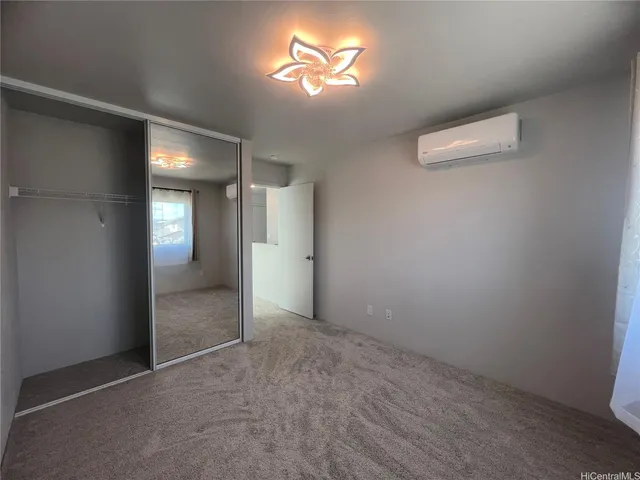 an empty room with closet and a chandelier fan