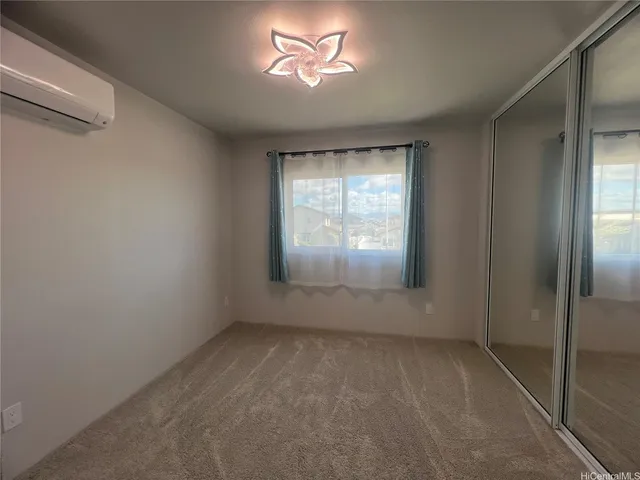 an empty room with windows and chandelier fan
