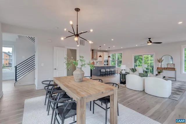 a view of a dining room and livingroom with furniture wooden floor a chandelier