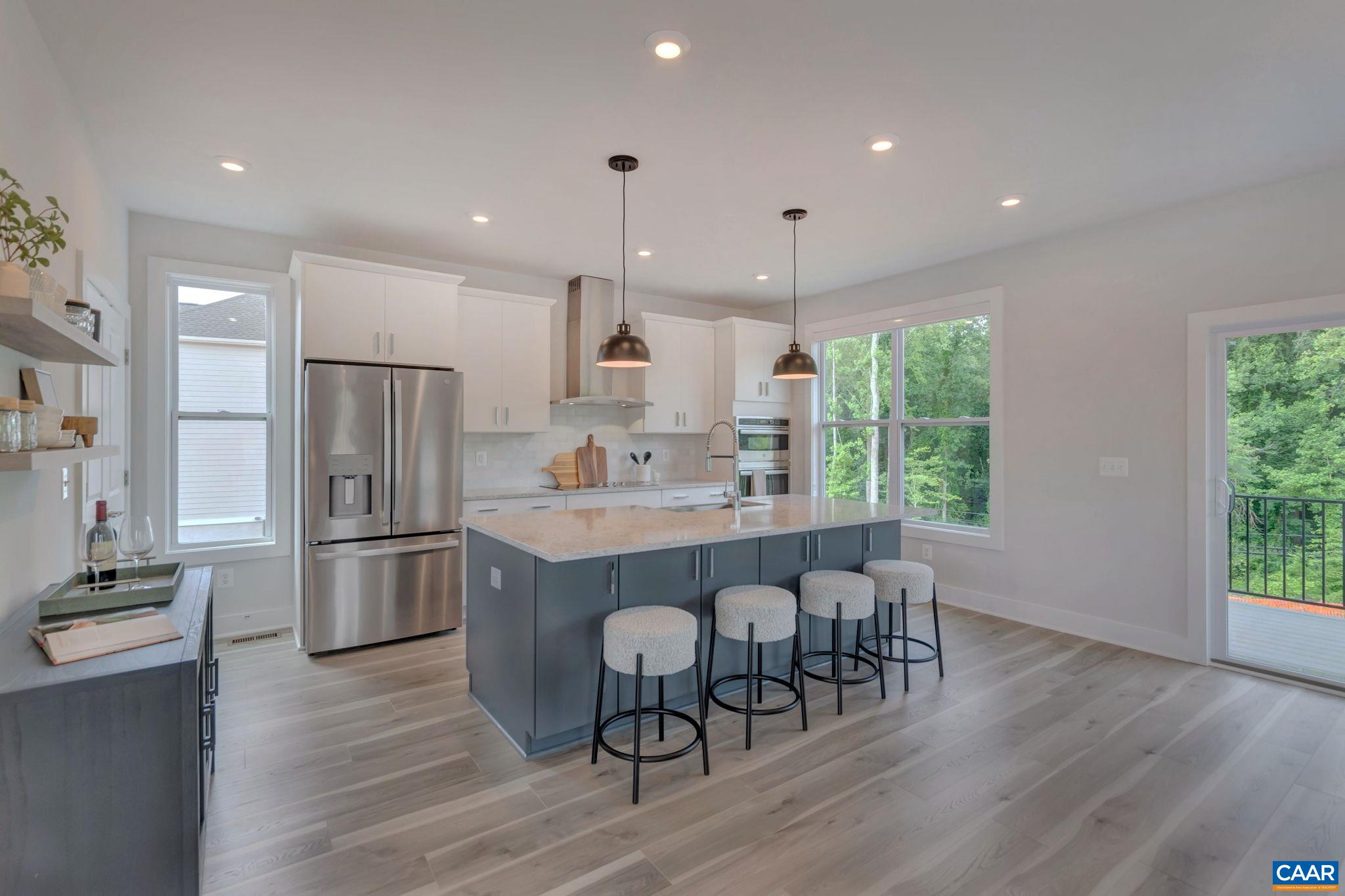 31 B Fowler Street Charlottesville, VA 22901 - Photo 6 of 26 a kitchen with kitchen island wooden floors white cabinets and stainless steel appliances