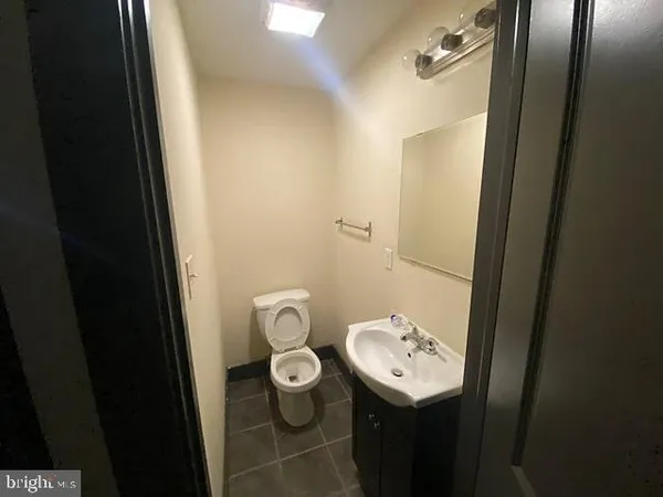 a bathroom with a toilet sink and mirror