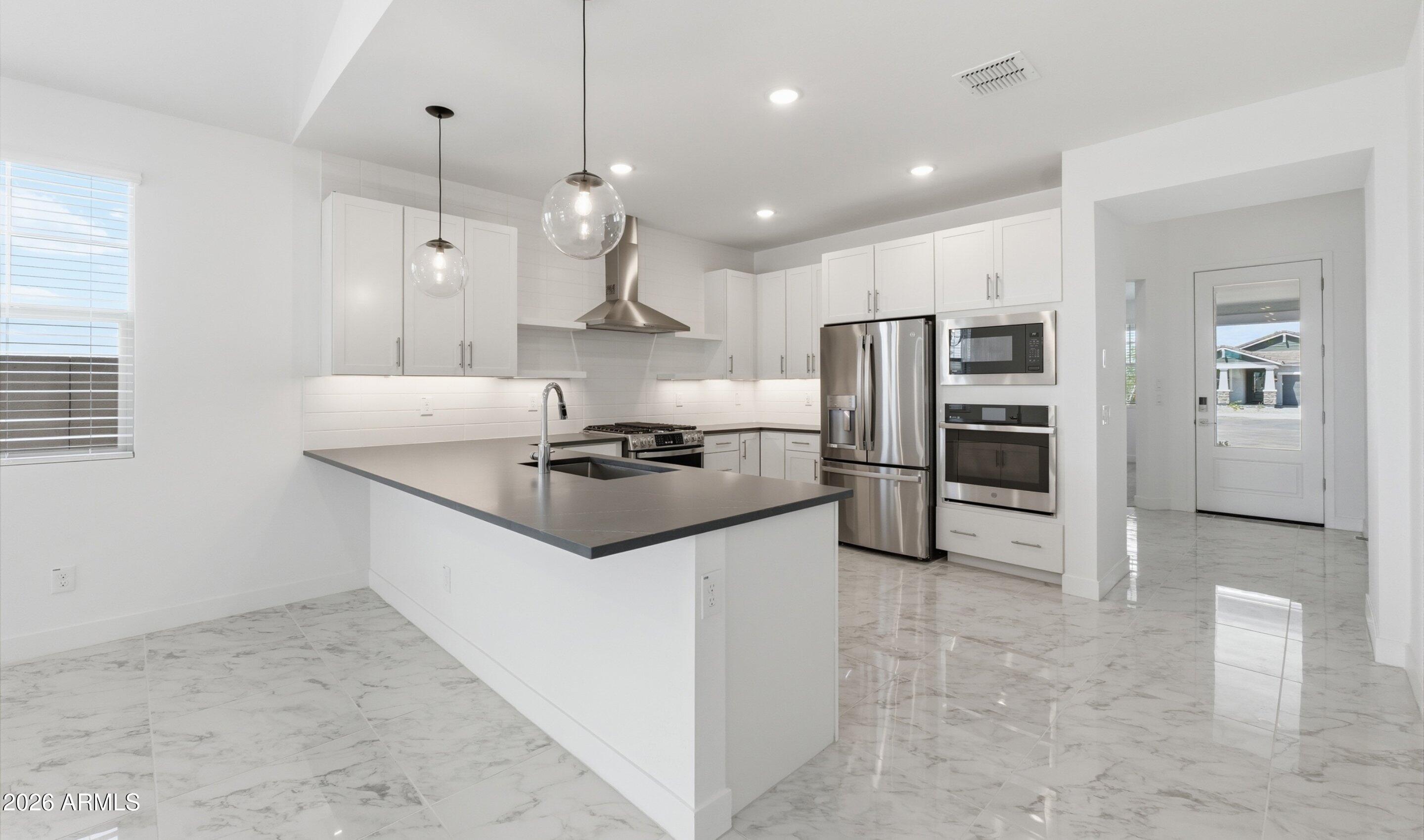 7779 West Sands Road Glendale, AZ 85303 - Photo 5 of 37 a kitchen with stainless steel appliances a refrigerator and a stove top oven