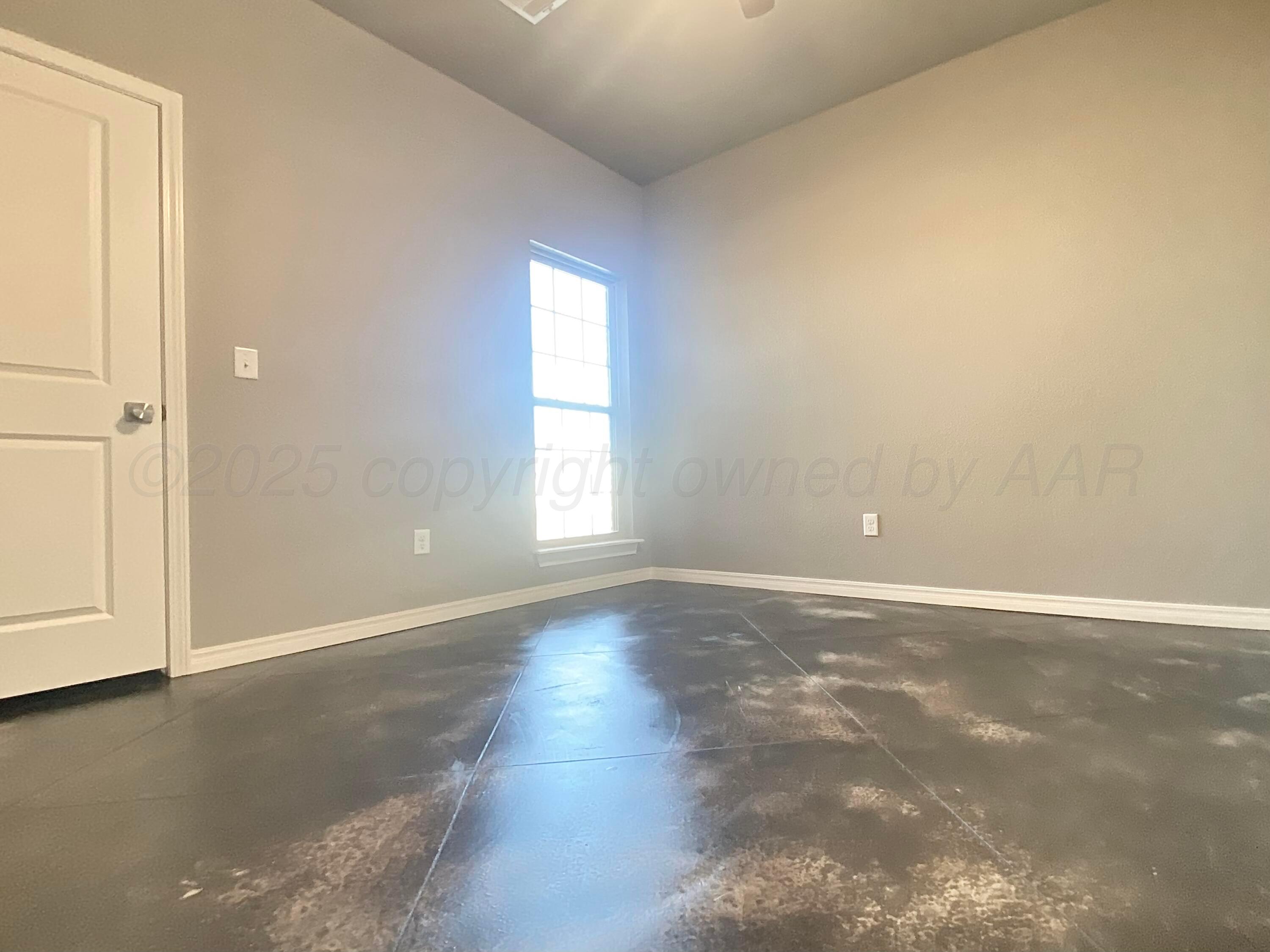 7517 John Thomas Street Amarillo, TX 79119 - Photo 13 of 20 an empty room with wooden floor and windows with curtains