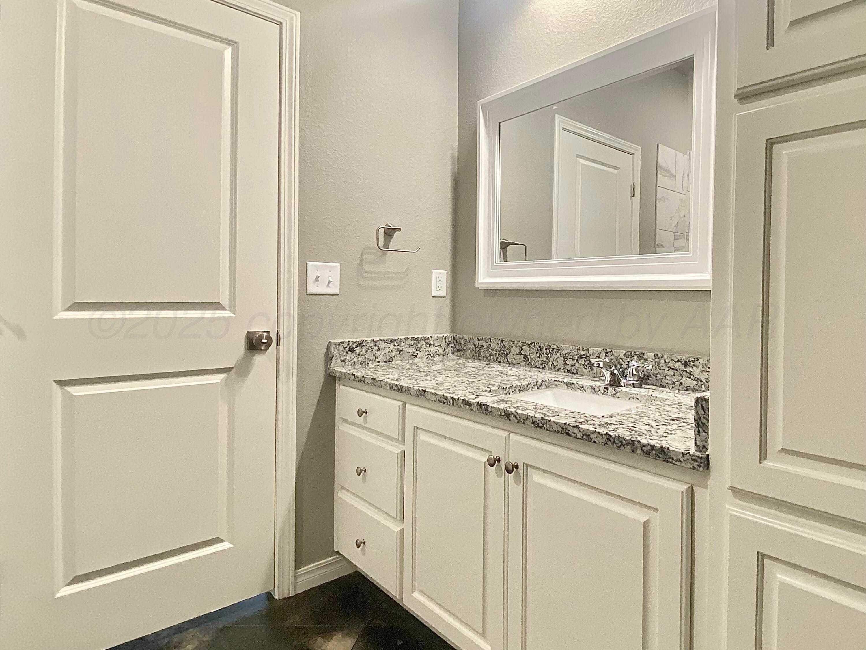 7517 John Thomas Street Amarillo, TX 79119 - Photo 14 of 20 a bathroom with a granite countertop sink and a mirror