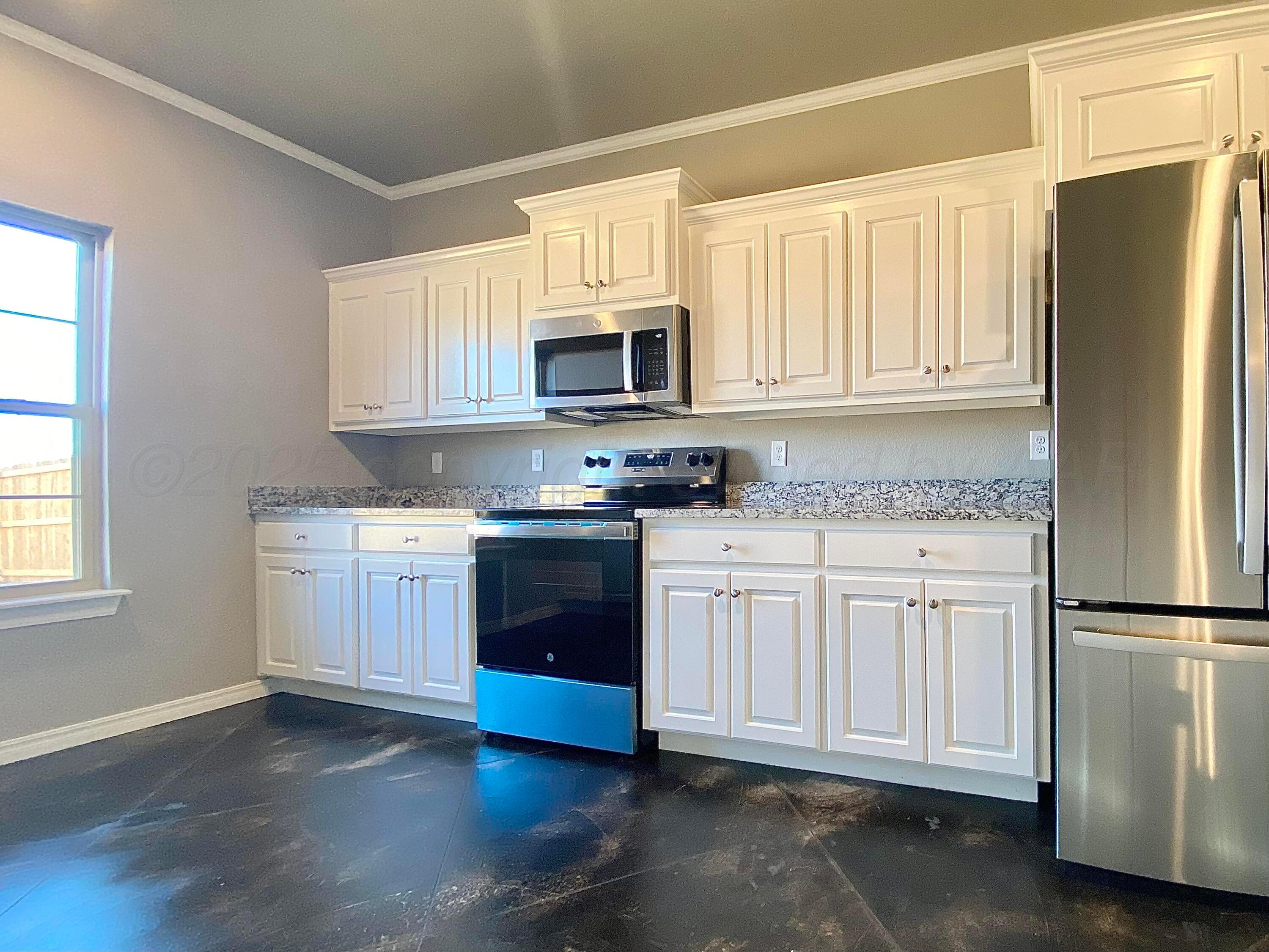 7517 John Thomas Street Amarillo, TX 79119 - Photo 5 of 20 a kitchen with granite countertop white cabinets and refrigerator