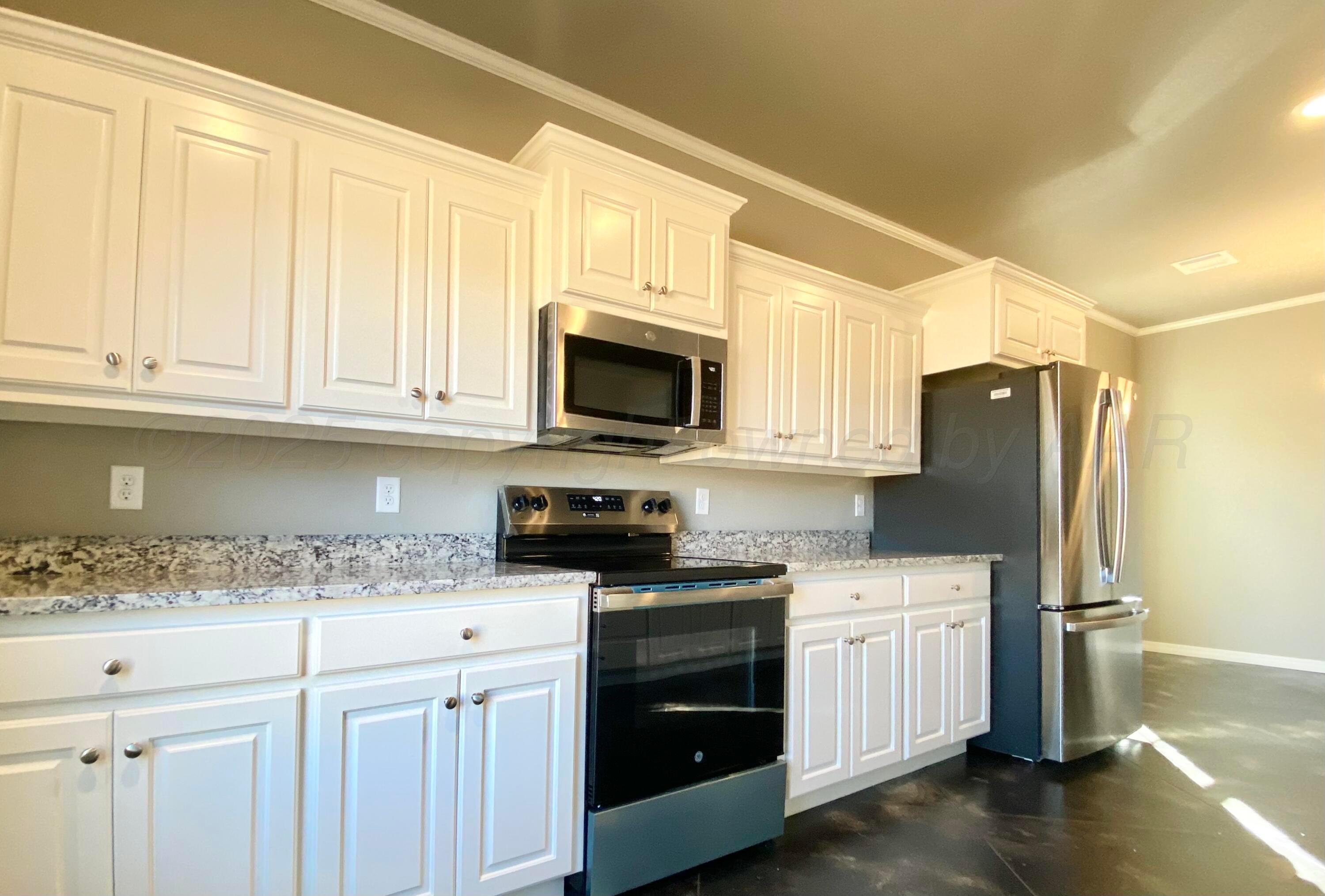 7517 John Thomas Street Amarillo, TX 79119 - Photo 7 of 20 a kitchen with stainless steel appliances granite countertop a refrigerator a stove a sink and white cabinets