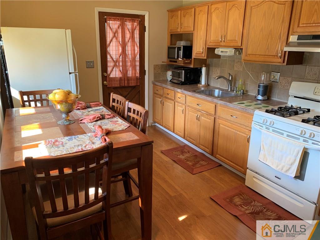 15 Sanders Road Edison, NJ 08817 - Photo 5 of 13 a kitchen with stainless steel appliances granite countertop a stove a sink dishwasher and cabinets with wooden floor
