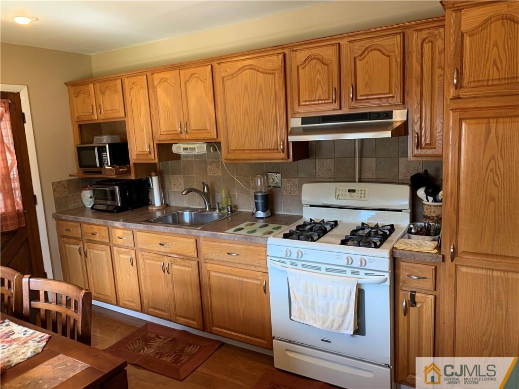 15 Sanders Road Edison, NJ 08817 - Photo 6 of 13 a kitchen with stainless steel appliances granite countertop a stove a sink and cabinets