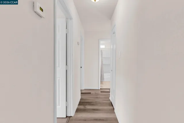 a view of an empty room with wooden floor