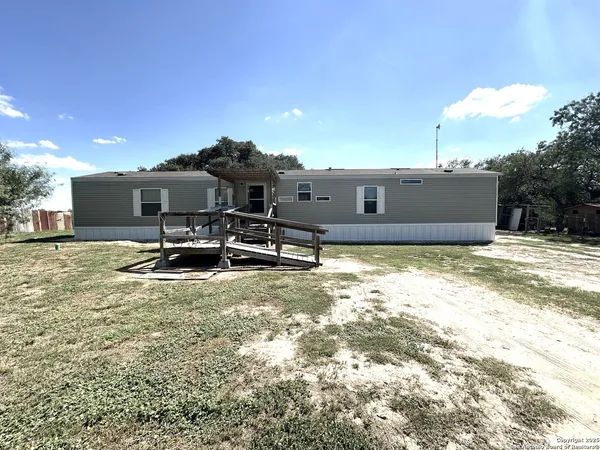 a view of a house with a backyard and sitting area