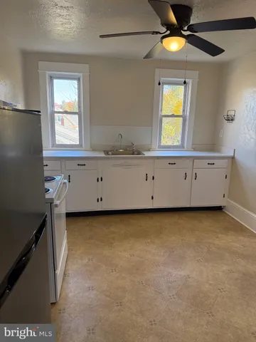 a view of an empty room with window and cabinet