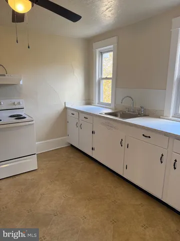 a room with a sink cabinets and a window