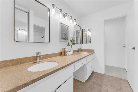 a bathroom with a granite countertop sink double and a mirror