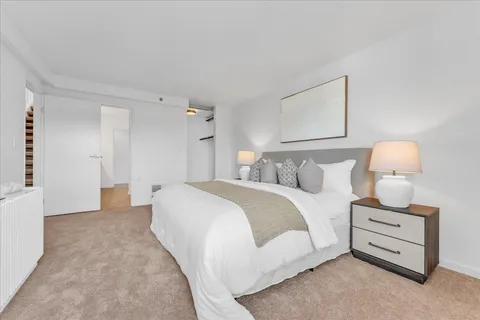 a spacious bedroom with a bed and a lamp