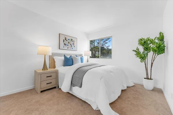 a bedroom with a bed and a potted plant