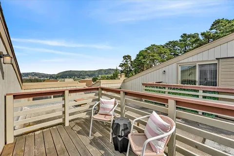a view of a balcony with chairs and wooden floor