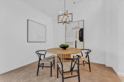 a view of a dining room that has a table and chairs in it