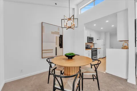 a view of a dining room with furniture and a chandelier