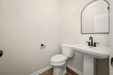a bathroom with a toilet a sink and mirror