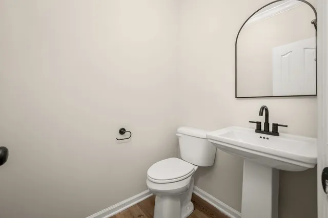 a bathroom with a toilet a sink and mirror