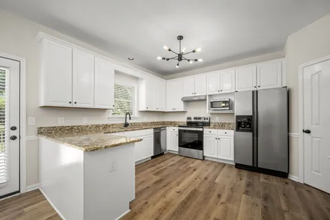 a kitchen with a refrigerator cabinets and wooden floor