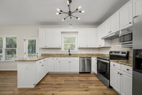 a kitchen with stainless steel appliances granite countertop a stove sink and cabinets