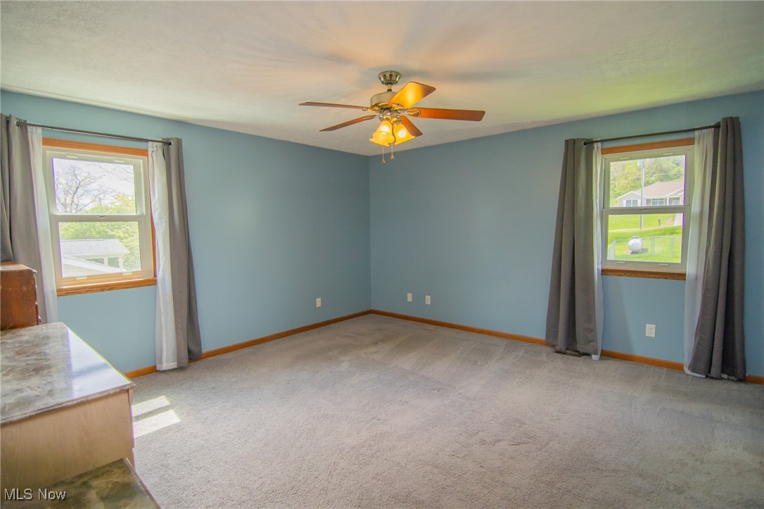 53350 High Ridge Road Bridgeport, OH 43912 - Photo 15 of 37 Carpeted empty room with ceiling fan and baseboards