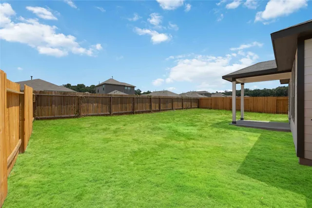 a view of an house with backyard space and balcony