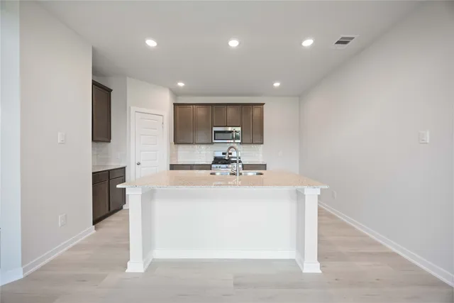 a view of kitchen with sink refrigerator and window