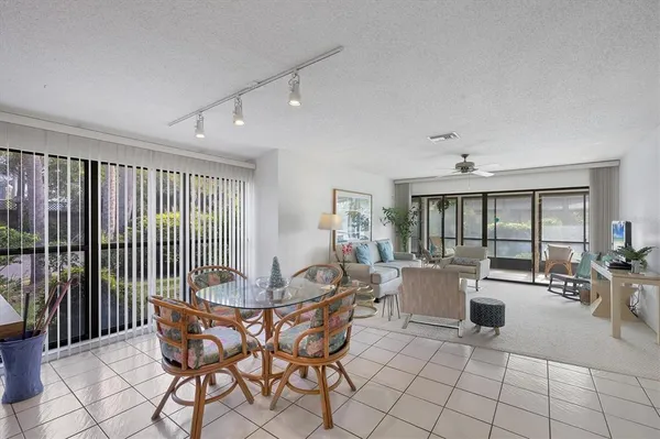 a dining room with furniture a chandelier and wooden floor