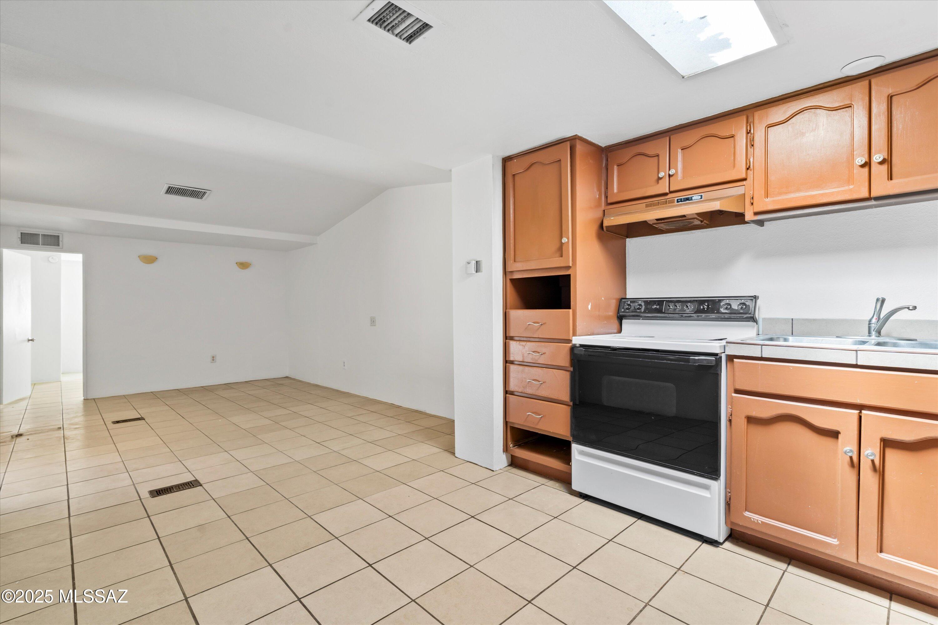 1227 East Ginter Road Tucson, AZ 85706 - Photo 14 of 18 a kitchen with stainless steel appliances granite countertop a stove and a sink