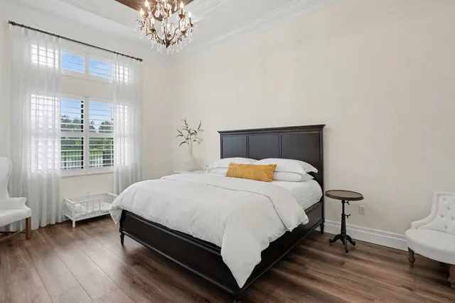 a bedroom with a bed a dresser and a flat screen tv