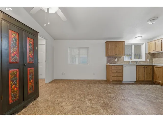 a view of kitchen with stainless steel appliances granite countertop a sink and cabinets