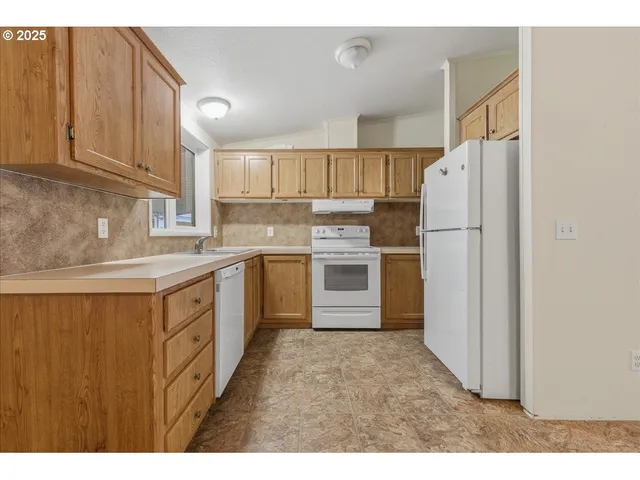 a kitchen with refrigerator cabinets and a sink