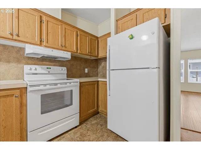 a white refrigerator freezer and a stove sitting inside of a kitchen