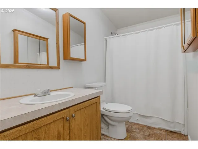 a bathroom with a granite countertop sink toilet and a mirror