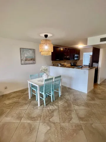 a living room with furniture a dining table and a refrigerator