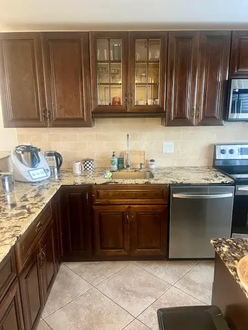 a kitchen with stainless steel appliances granite countertop a sink dishwasher stove and cabinets