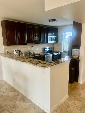 a kitchen with stainless steel appliances granite countertop a sink and a stove