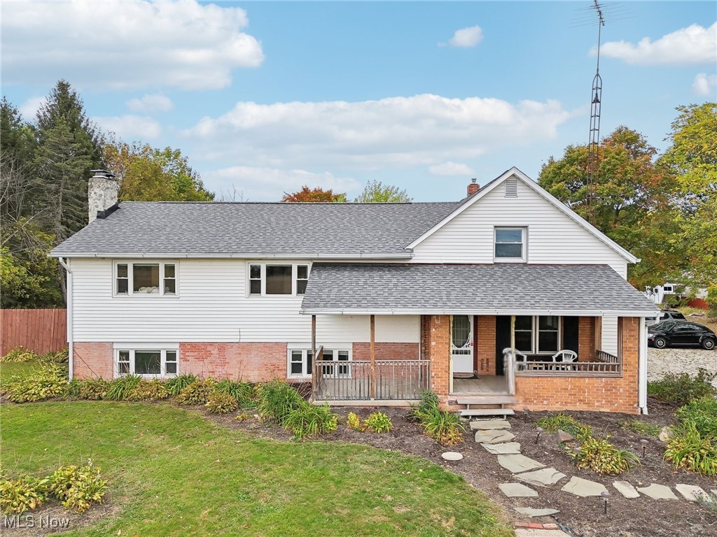 22120 Center Road Alliance, OH 44601 - Photo 11 of 41 View of front of home with covered porch, brick siding, a chimney, and a shingled roof