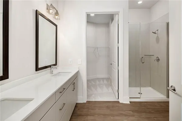 a bathroom with a double vanity sink mirror and shower