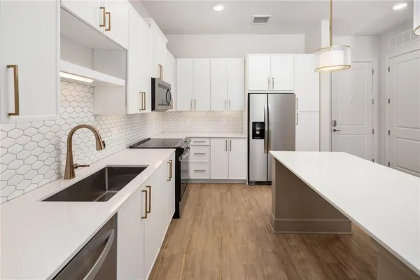 a kitchen with a sink a refrigerator and cabinets