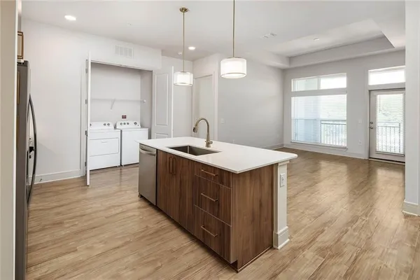 a kitchen with stainless steel appliances granite countertop a sink a counter space and wooden floor