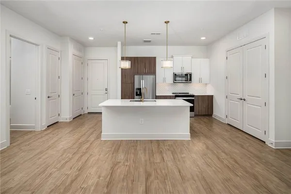 a large kitchen with stainless steel appliances kitchen island a large counter space and wooden floors