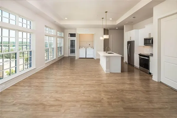 a view of a kitchen with furniture and wooden floor
