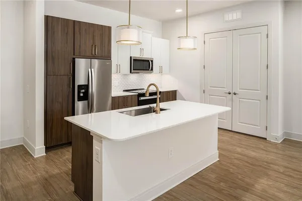 a kitchen with a white center island a refrigerator and cabinets