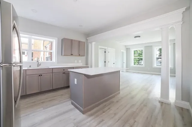a large kitchen with a lot of counter space and wooden floor