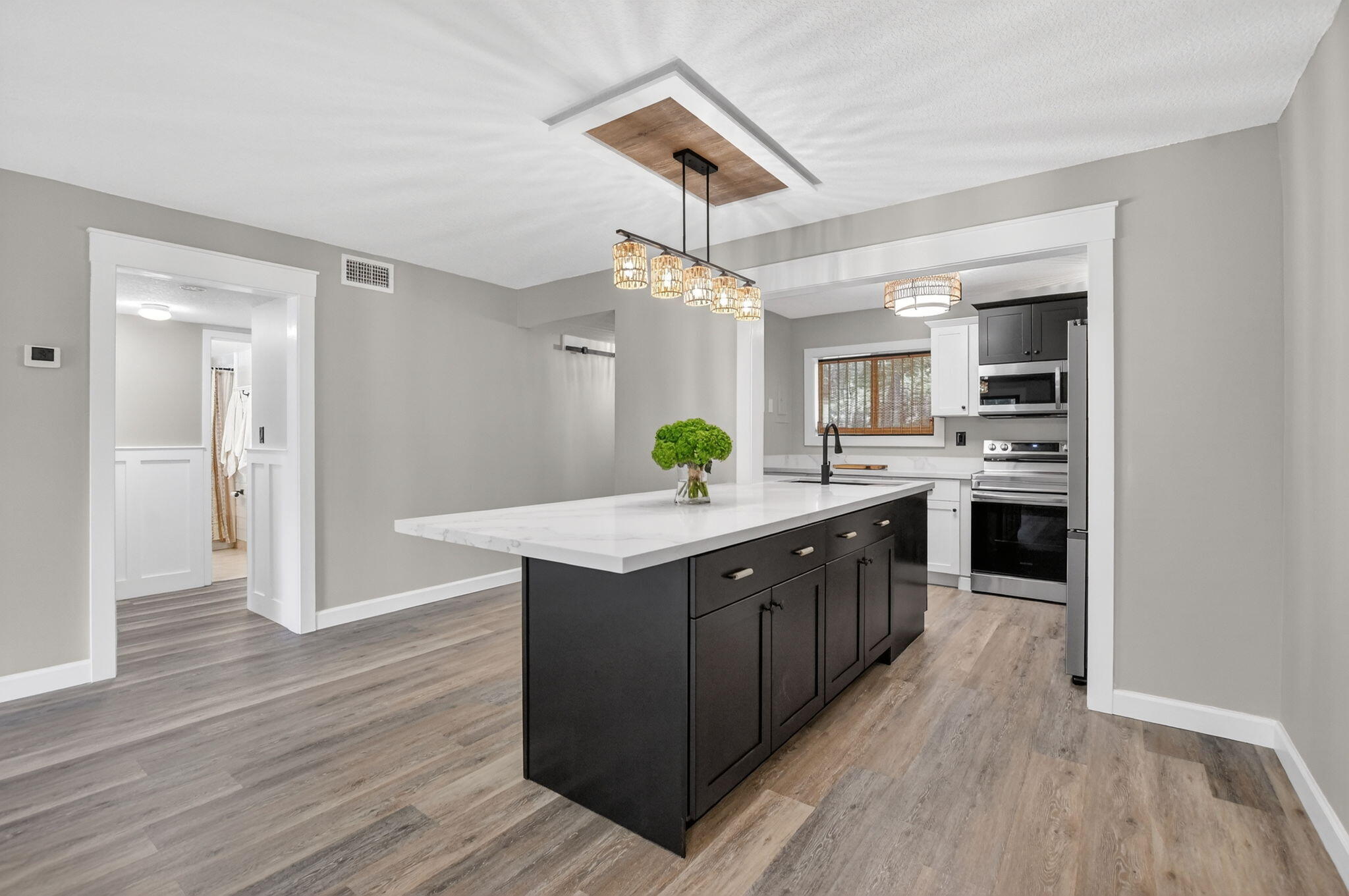 a kitchen with kitchen island granite countertop a sink cabinets and wooden floor
